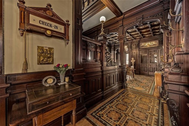 interior space with coffered ceiling and a decorative wall