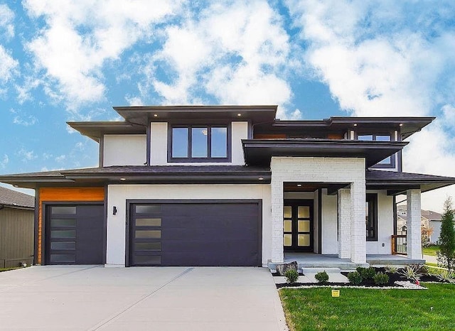 view of front of property featuring driveway, an attached garage, and stucco siding