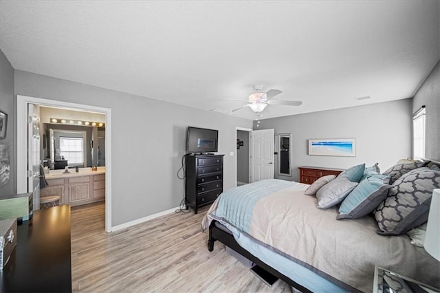 bedroom featuring visible vents, baseboards, a ceiling fan, ensuite bathroom, and light wood-style floors