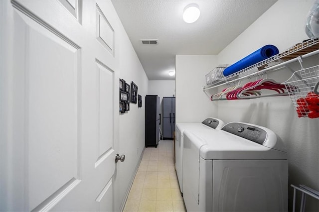 laundry room with a textured ceiling, laundry area, washer and clothes dryer, and visible vents