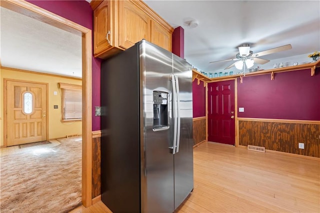 kitchen with ceiling fan, a wainscoted wall, visible vents, stainless steel refrigerator with ice dispenser, and light wood finished floors