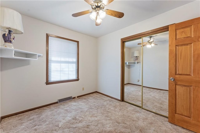 unfurnished bedroom featuring a closet, visible vents, a ceiling fan, light carpet, and baseboards