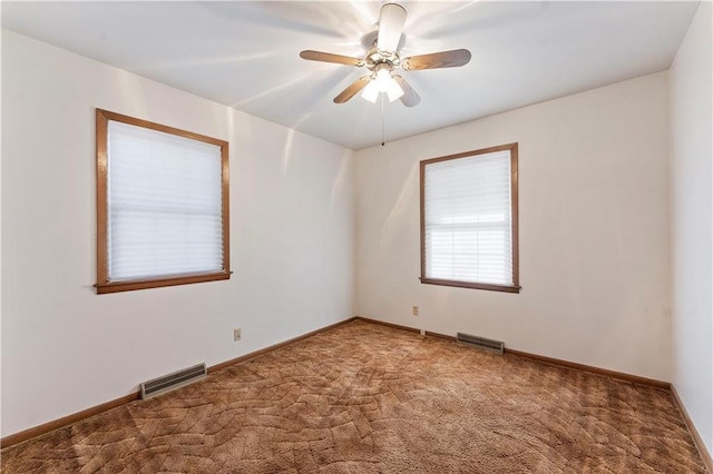 unfurnished room with carpet floors, baseboards, and visible vents