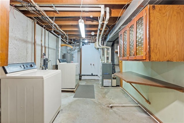 unfinished basement with water heater, washing machine and clothes dryer, and heating unit