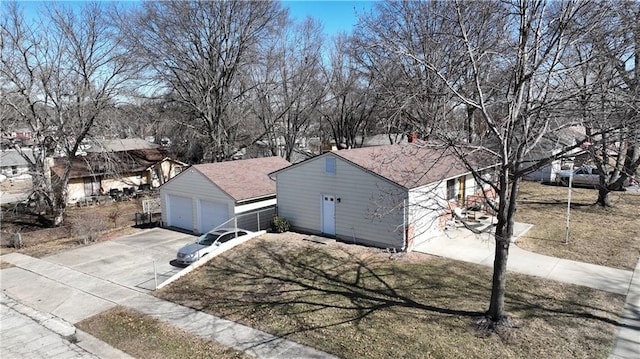 single story home with a front yard and a detached garage