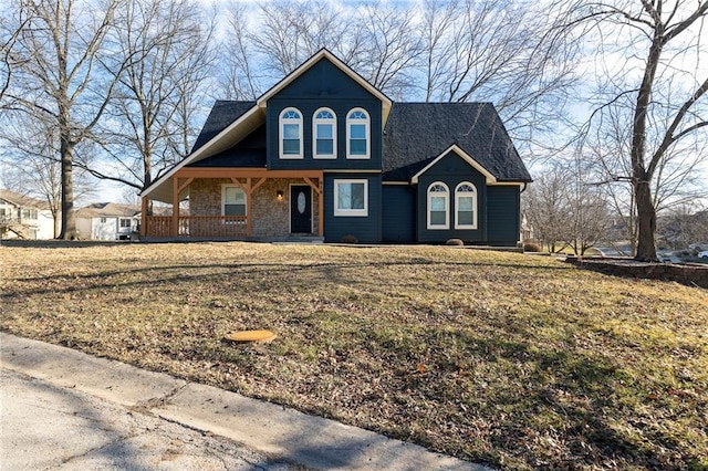 view of front of property featuring covered porch, roof with shingles, and a front lawn