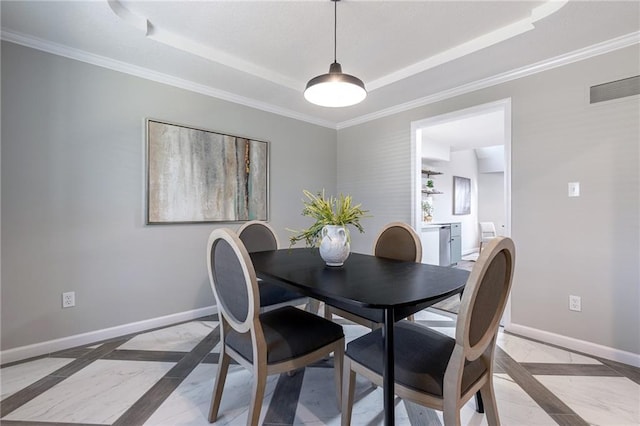 dining space featuring visible vents, baseboards, a raised ceiling, and ornamental molding