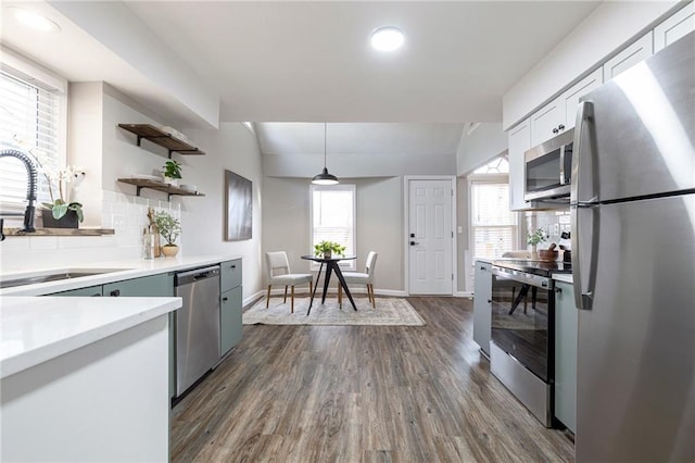 kitchen featuring lofted ceiling, appliances with stainless steel finishes, open shelves, and a sink