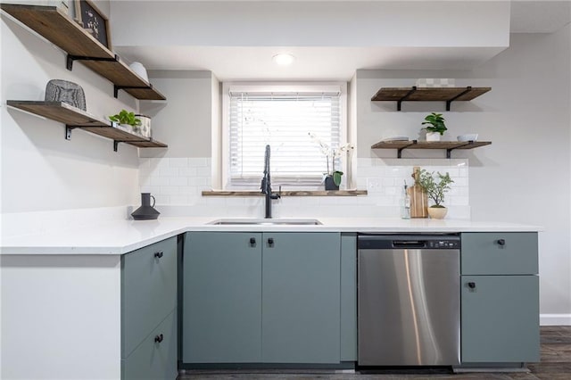 kitchen featuring open shelves, light countertops, backsplash, stainless steel dishwasher, and a sink