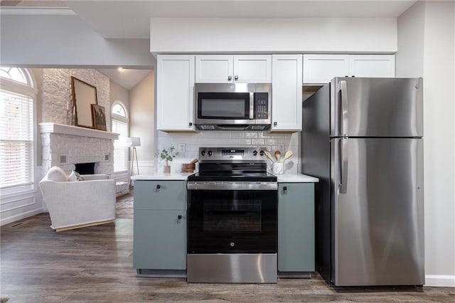 kitchen featuring dark wood-style floors, stainless steel appliances, plenty of natural light, and decorative backsplash