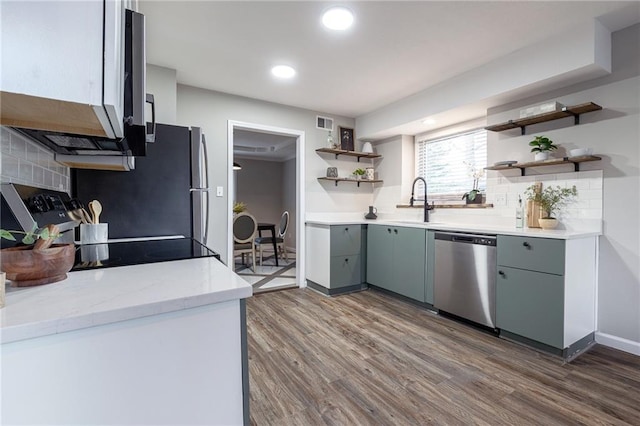 kitchen featuring visible vents, dark wood-style floors, stainless steel dishwasher, open shelves, and a sink