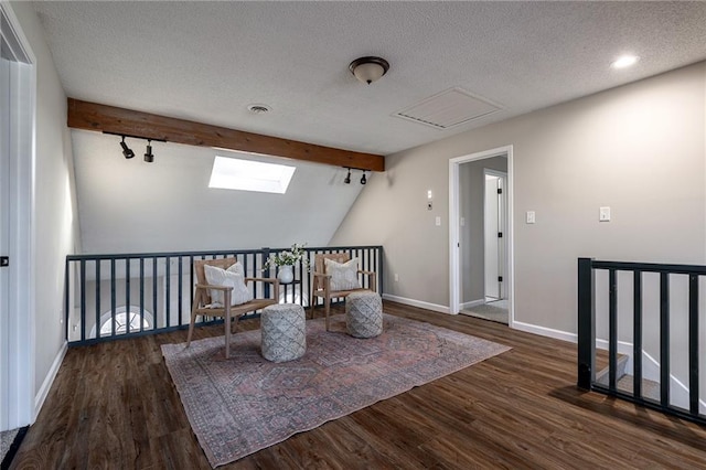 unfurnished room featuring a textured ceiling, baseboards, track lighting, and wood finished floors