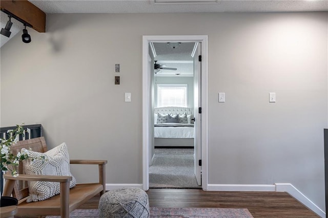 interior space featuring a textured ceiling, wood finished floors, and baseboards