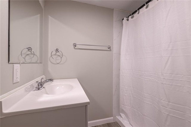 bathroom featuring curtained shower, baseboards, and vanity