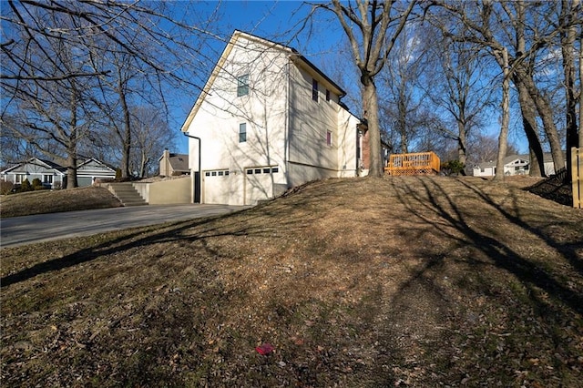 view of side of home with a garage and driveway