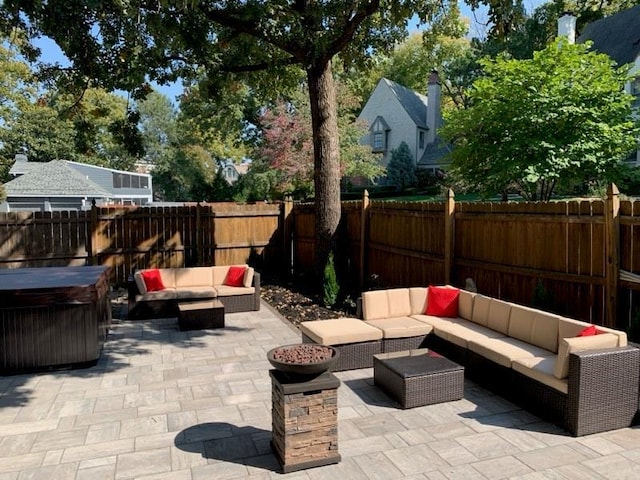 view of patio featuring an outdoor living space, a fenced backyard, and a hot tub