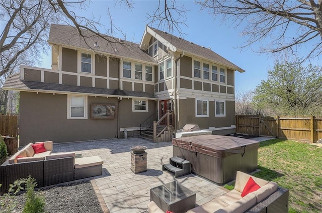 back of house with stucco siding, a patio area, fence private yard, and a hot tub