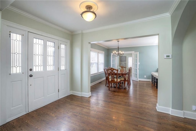 entrance foyer with crown molding, a notable chandelier, baseboards, and dark wood-style flooring