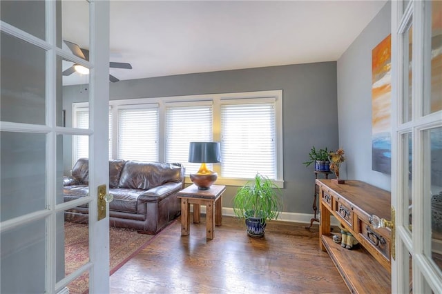 living room with a ceiling fan, wood finished floors, french doors, and baseboards