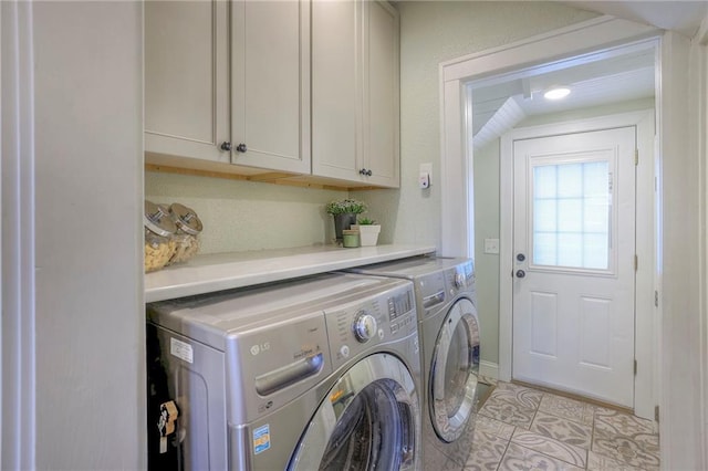 washroom featuring separate washer and dryer, light tile patterned floors, and cabinet space