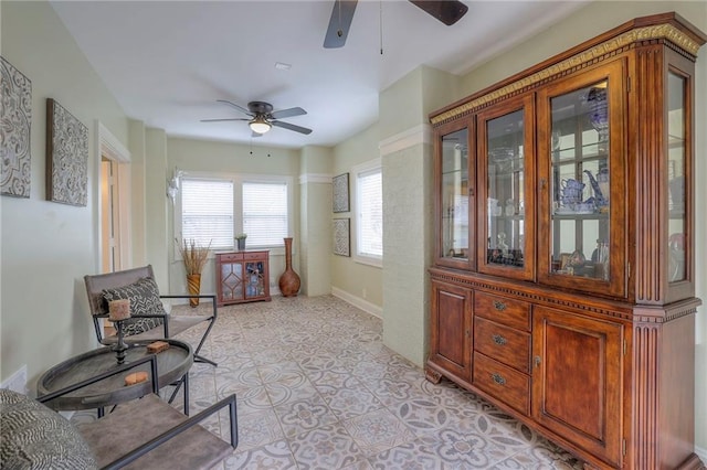 sitting room with baseboards and ceiling fan