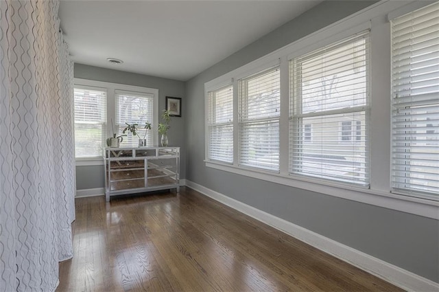 empty room featuring baseboards and hardwood / wood-style flooring