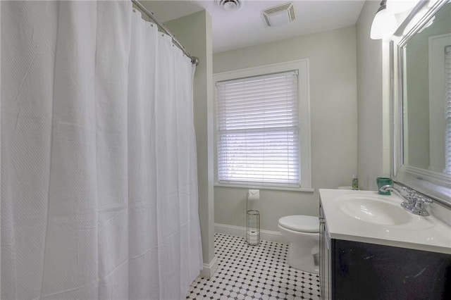 full bathroom featuring vanity, baseboards, visible vents, tile patterned flooring, and toilet