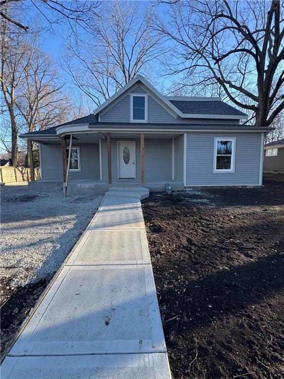 view of front of property with a porch and roof with shingles