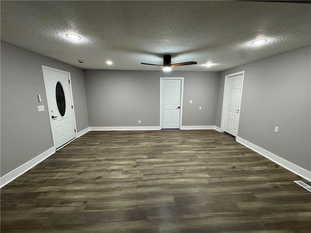 spare room featuring dark wood-type flooring, visible vents, ceiling fan, and baseboards