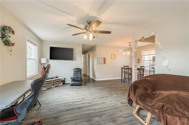 living room with a healthy amount of sunlight, a ceiling fan, baseboards, and wood finished floors