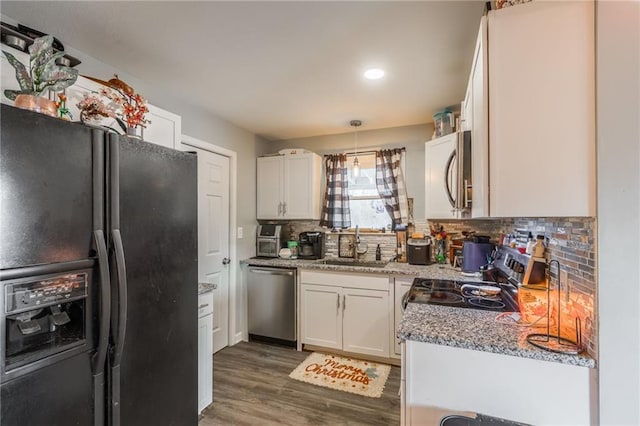 kitchen with dark wood-style flooring, backsplash, appliances with stainless steel finishes, white cabinetry, and a sink