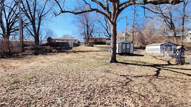 view of yard featuring an outbuilding, a storage shed, and fence