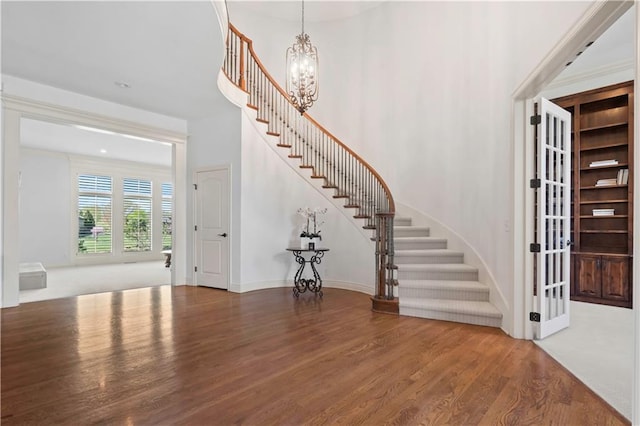 15300 Mastin St, Overland Park, KS 66221 - entryway with wood finished floors, a notable chandelier, baseboards, and stairs