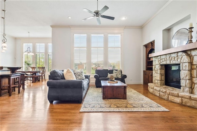 15300 Mastin St, Overland Park, KS 66221 - living area featuring baseboards, a stone fireplace, ornamental molding, ceiling fan, and wood finished floors