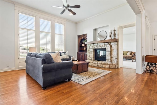 15300 Mastin St, Overland Park, KS 66221 - living room featuring baseboards, a stone fireplace, a ceiling fan, crown molding, and wood finished floors