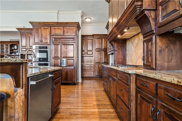 15300 Mastin St, Overland Park, KS 66221 - kitchen with crown molding, stainless steel appliances, premium range hood, light wood finished floors, and backsplash