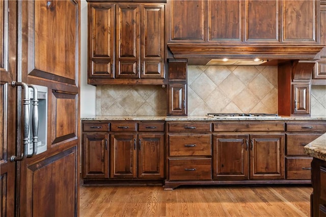 15300 Mastin St, Overland Park, KS 66221 - kitchen with tasteful backsplash, ventilation hood, dark wood-style floors, stainless steel gas cooktop, and light stone counters