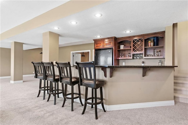 15300 Mastin St, Overland Park, KS 66221 - bar featuring a bar, light colored carpet, black fridge, and baseboards
