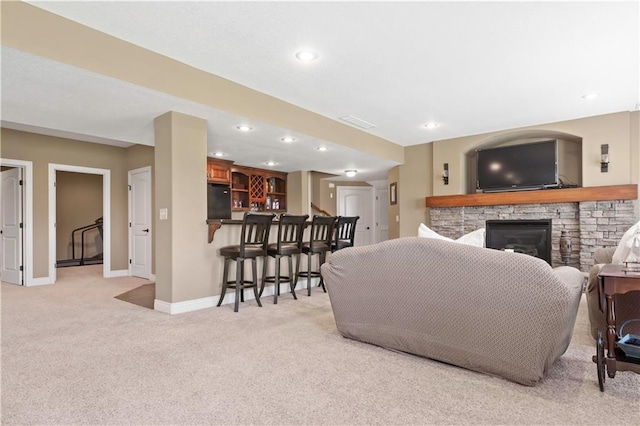 15300 Mastin St, Overland Park, KS 66221 - living room featuring baseboards, a stone fireplace, recessed lighting, bar, and light carpet
