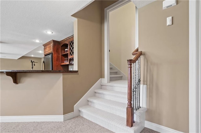 15300 Mastin St, Overland Park, KS 66221 - stairway with indoor wet bar, baseboards, recessed lighting, a textured ceiling, and carpet floors