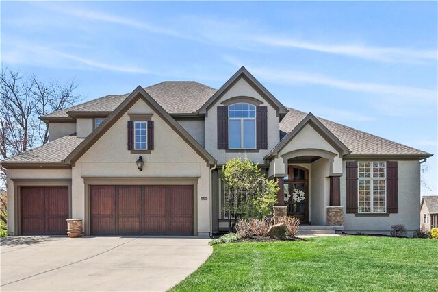 15300 Mastin St, Overland Park, KS 66221 - view of front facade with a garage, concrete driveway, stucco siding, a front lawn, and roof with shingles
