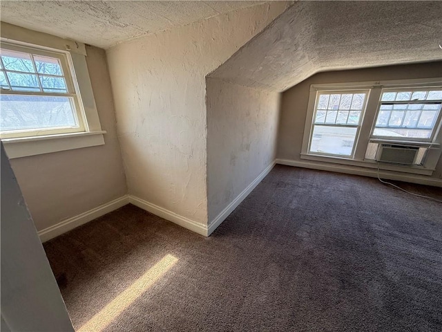 bonus room with lofted ceiling, a wealth of natural light, baseboards, and a textured ceiling