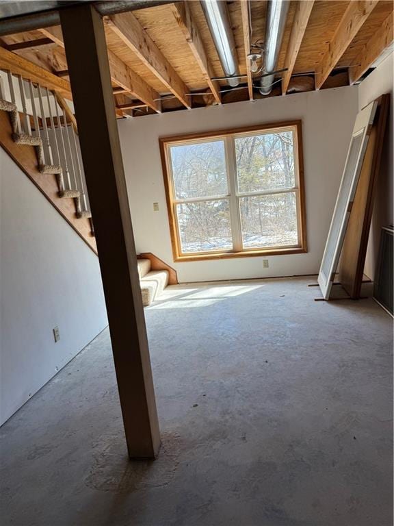 interior space featuring stairway and unfinished concrete floors