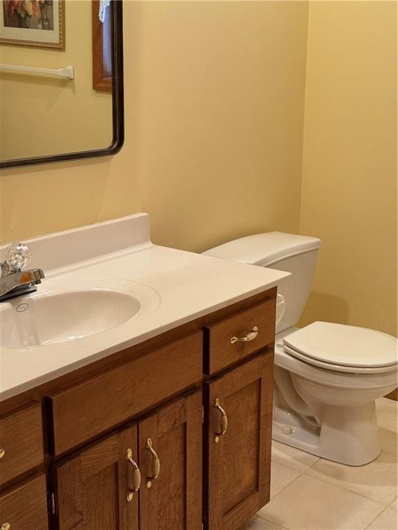 half bath featuring tile patterned flooring, vanity, and toilet