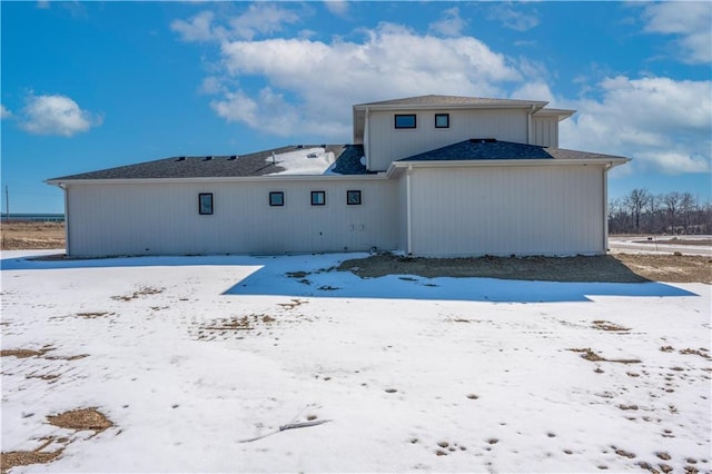 view of snow covered back of property