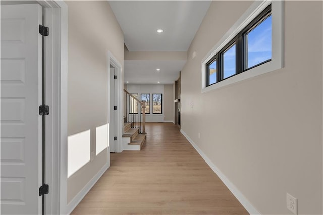 hall with stairway, recessed lighting, light wood-style flooring, and baseboards