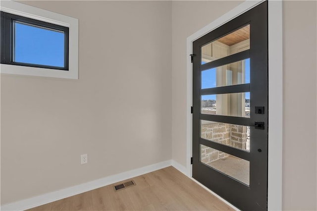 entryway featuring visible vents, baseboards, and wood finished floors