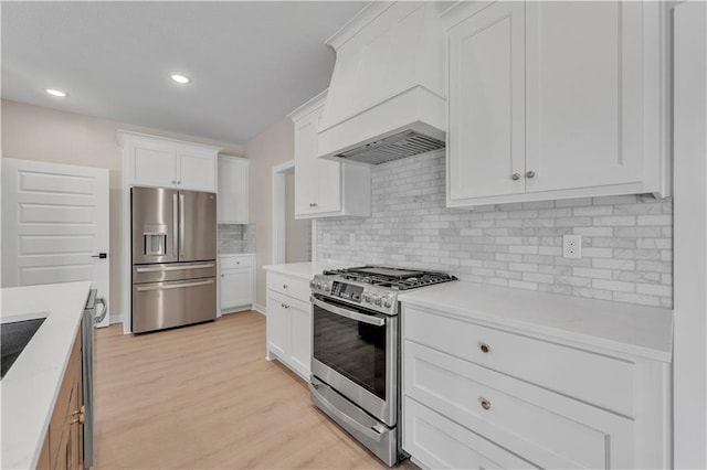 kitchen featuring white cabinets, light wood-style flooring, appliances with stainless steel finishes, and light countertops