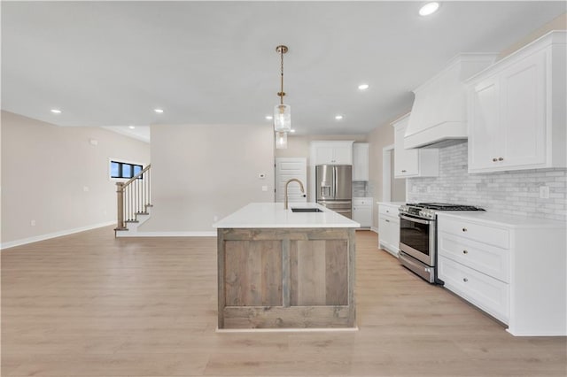 kitchen featuring custom exhaust hood, stainless steel appliances, decorative backsplash, light wood-style floors, and a sink