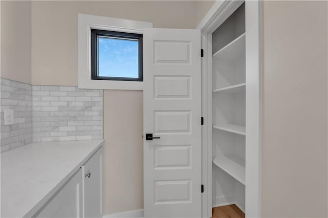 interior space with backsplash and vanity